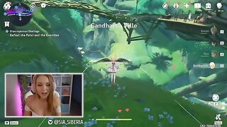 A gamer girl streams herself playing Genshin Impact with a huge toy