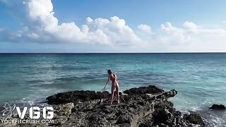 A naked girl is playing on the beach in a naughty way