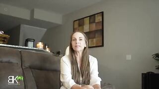 A stepmom shares a couch with her stepson in a taboo roleplay scene