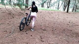 A beautiful brunette takes a bike ride through the forest and meets a friend