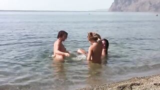 Three naked beauties on the coast, sunbathing without any clothes