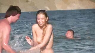 A mature woman sunbathes naked on the beach