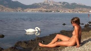 A hot girl is walking on the riverbank completely naked
