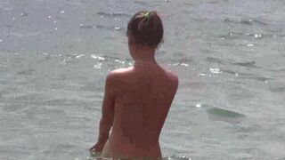 Nude beauty at the beach, sunbathing naked