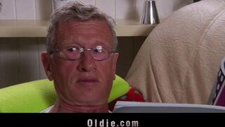 A young girl is having fun with an older gentleman on the couch