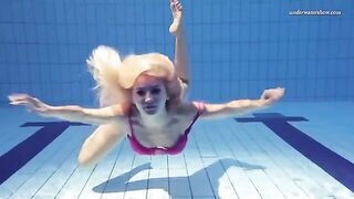 Nude beauty has fun in the pool and shows her forms