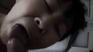 An adult Chinese woman practices her blowjob skills on a man’s dick