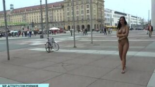 A hot chick is walking naked on the city streets