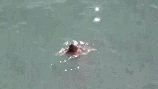A couple enjoy each other without any clothes on the sea