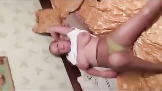 A pregnant woman is milking her boobs for a photographer