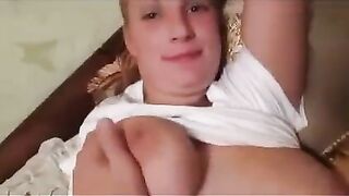 A pregnant woman is milking her boobs for a photographer