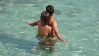 A girl fingers a guy's cock while they are underwater