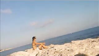 A young girl sunbathes naked on the beach. It's very dangerous