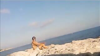 A young girl sunbathes naked on the beach. It's very dangerous