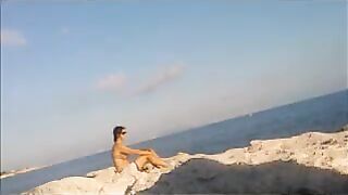 A young girl sunbathes naked on the beach. It's very dangerous