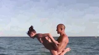A naked girl is doing gymnastics on the beach