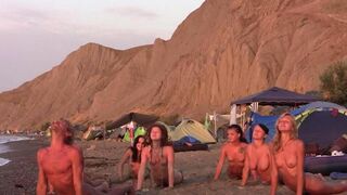 A group of naked people are playing volleyball on the nude beach