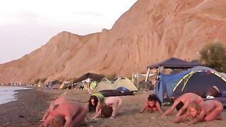A group of naked people are playing volleyball on the nude beach