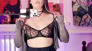 A girl caresses herself with a mirror, embodying alternative allure